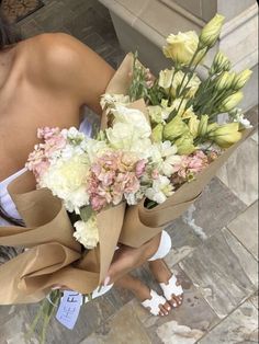 a woman is holding a bouquet of flowers