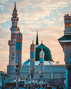 people standing in front of a large building with many spires and minarets