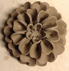 a clay flower sitting on top of a table