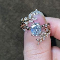 a woman's hand holding an engagement ring with a blue topazte surrounded by diamonds