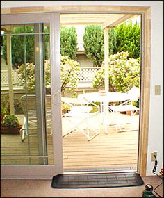 an open door leading to a patio with table and chairs in the back yard area