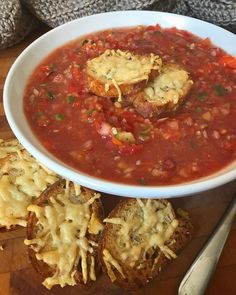 a white bowl filled with soup next to crackers