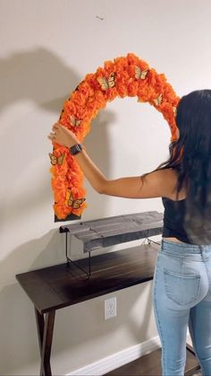 a woman holding up a wreath with flowers on it