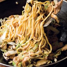 a wok filled with noodles and meat