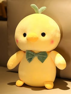 a yellow stuffed animal with a green bow tie on it's head and eyes