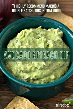 avocado spinach dip in a bowl with tortilla chips on the side