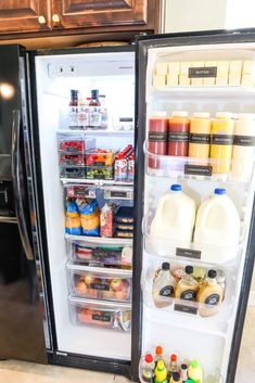 an open refrigerator with milk, juice and condiments on the door in a kitchen