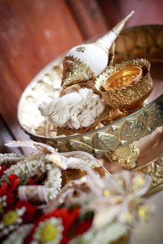 there are some gold and white items in the bowl on the table next to each other