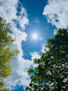 the sun shines brightly through the clouds above some trees