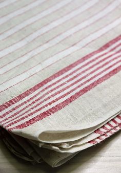 red and white striped napkins stacked on top of each other in front of a wooden table