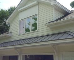 an image of a house that is painted white and has metal roofing on it