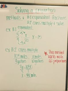 a white board with writing on it in front of a wall mounted sign that says, solve a fraction method