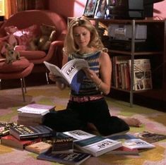 a woman sitting on the floor reading a book