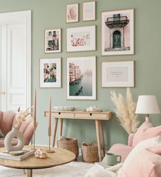 a living room filled with pink furniture and pictures on the wall above it's coffee table