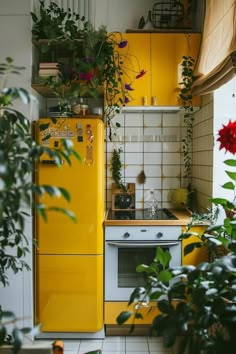 a kitchen with yellow appliances and plants growing on the wall above the stove, along with white tile flooring