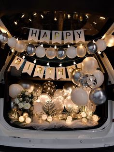 an open car door with balloons and decorations on it