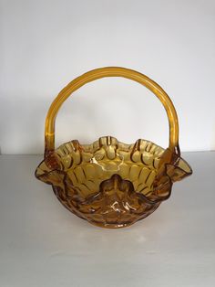 a brown glass basket with handles on a table