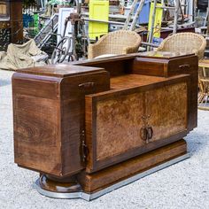 two wooden chairs sitting on top of a table next to each other in front of bikes