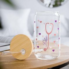 a glass jar sitting on top of a table next to a wooden coaster with a stethoscope in it