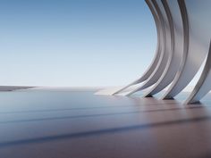 an abstract view of the ocean and sky from inside a building with curved concrete pillars