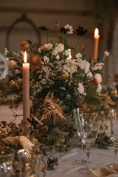 the table is set with flowers and candles