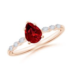 a pear shaped ruby and diamond ring in 18k rose gold with side stones on the band