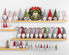 christmas gnomes are lined up on the shelves in front of a wreath and clock