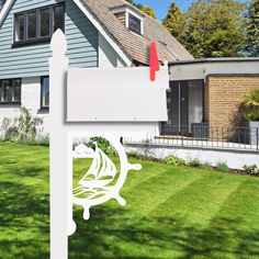 a white house with a sailboat on it's sign in front of the house