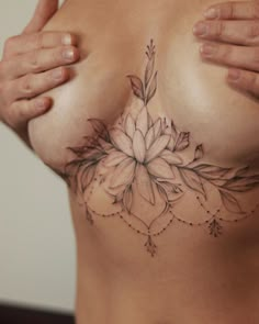 a close up of a woman's breast with flowers on it and leaves in the middle