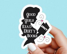 a person holding up a sticker with the words good girls read dirty books on it