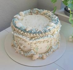 there is a cake that has shells on the bottom and blue ruffles around it