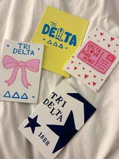 four different designs are displayed on a white sheet with the words delta, tri delta and delta