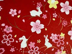 a red background with flowers and rabbits on it