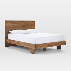 a wooden bed frame with white sheets and pillows