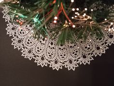 a white doily is hanging from a christmas tree