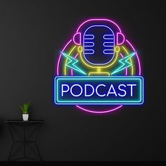 a neon sign that says podcast with a microphone in the center and a potted plant next to it