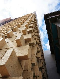 an upward view of a building made out of blocks