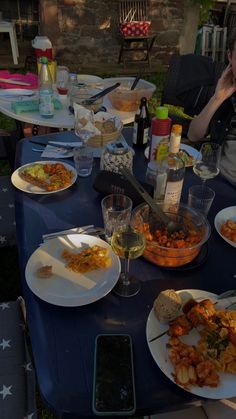 a woman sitting at a table covered in plates of food