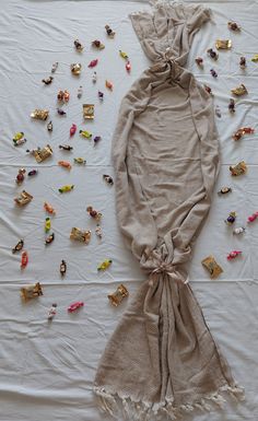 a scarf is laying on top of a table covered in pins and other things that are scattered around it