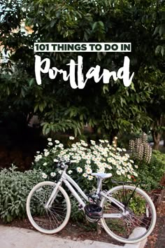 a bike parked next to a bush with daisies in the foreground and text overlay that reads 101 things to do in portland