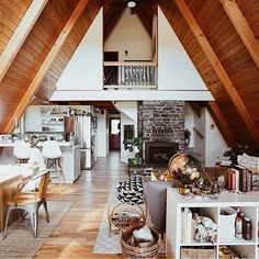 an open living room and dining area in a house with wood floors, vaulted ceiling