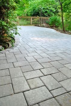 a stone walkway in the middle of a wooded area