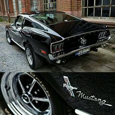 an old mustang is parked in front of a brick building and next to another car