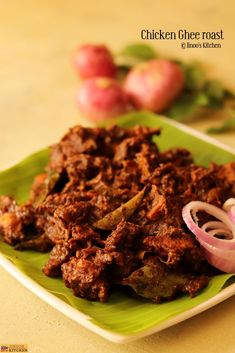 a green plate topped with meat and onions next to red onion on top of a table