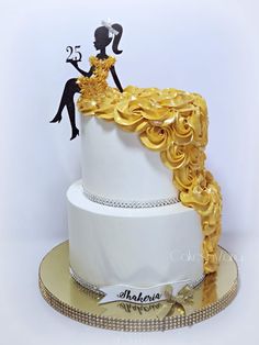 a white and gold wedding cake with black silhouettes on top