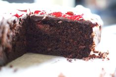 a chocolate cake with cherries is cut in half