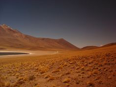 an empty desert with mountains in the background