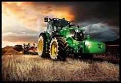 a large green tractor is parked in the middle of a field