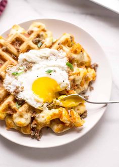 a plate with waffles and an egg on top