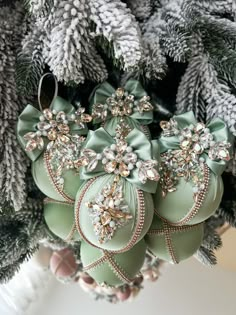 green ornaments are hanging from a christmas tree